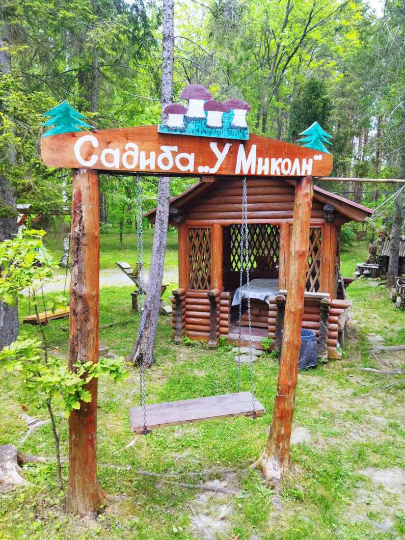 Вхідна вивіска садиби «У Миколи» серед лісу